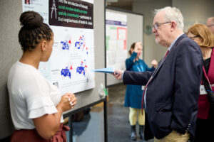 UMSL assistant professor Devin Banks, PhD, discusses her poster with Bill Powderly, MD, during the ICTS symposium on May 18, 2023 at EPNEC. MATT MILLER/WASHINGTON UNIVERSITY SCHOOL OF MEDICINE